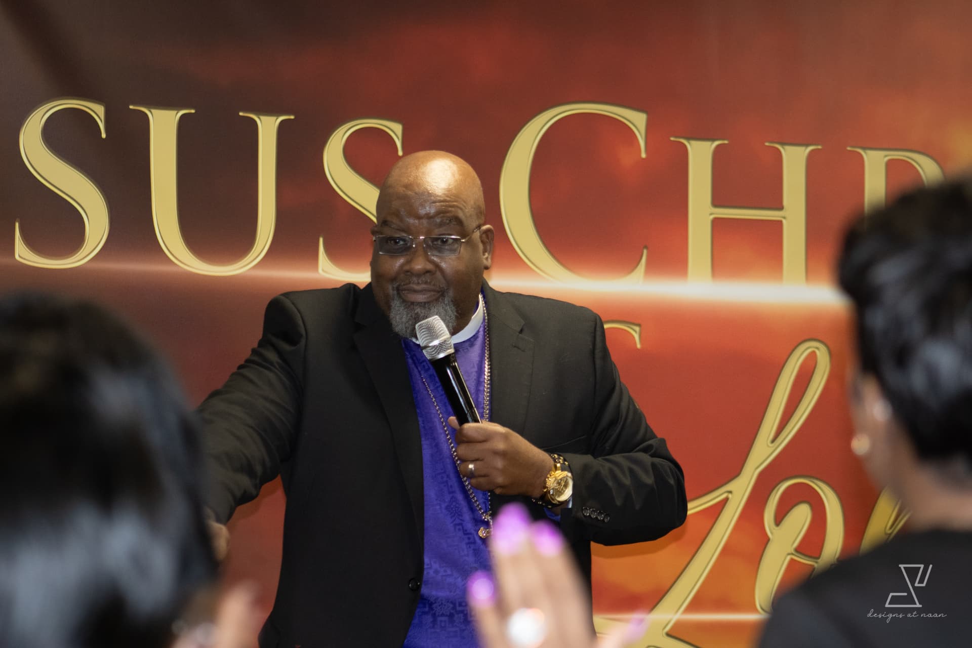 Bishop reaching out to the congregation with a microphone during service