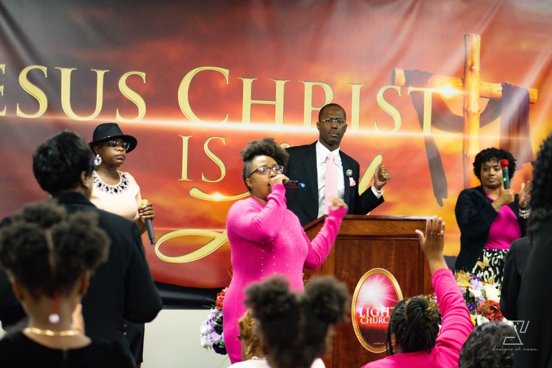 Worship team singing together at the pulpit with raised hands