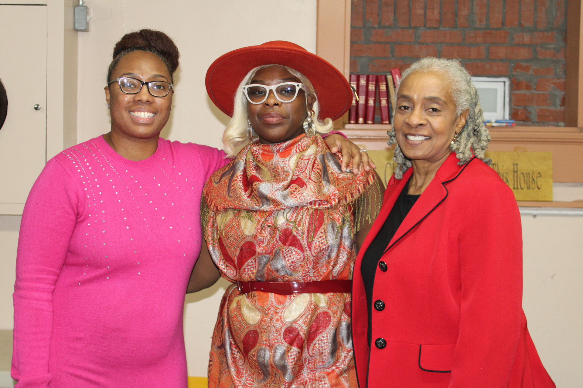 Three church members posing together in the fellowship hall after service